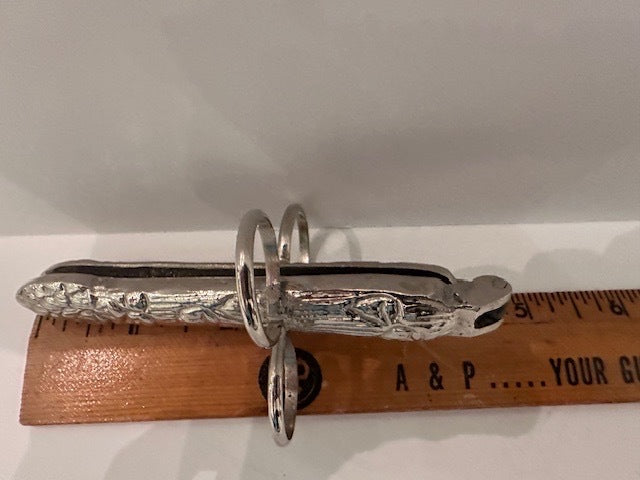 Hinged asparagus utensil beside a wooden ruler indicating over five inches long