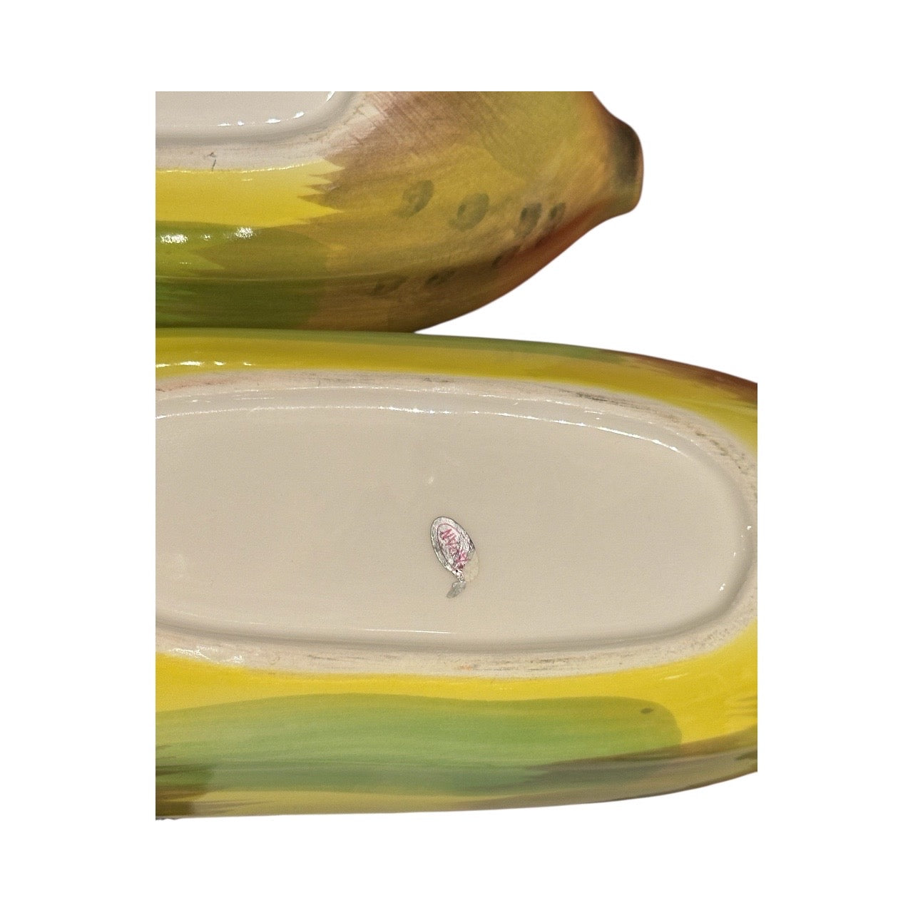 Close-up of two banana split bowls; underside shows white base with original maker's paper label.