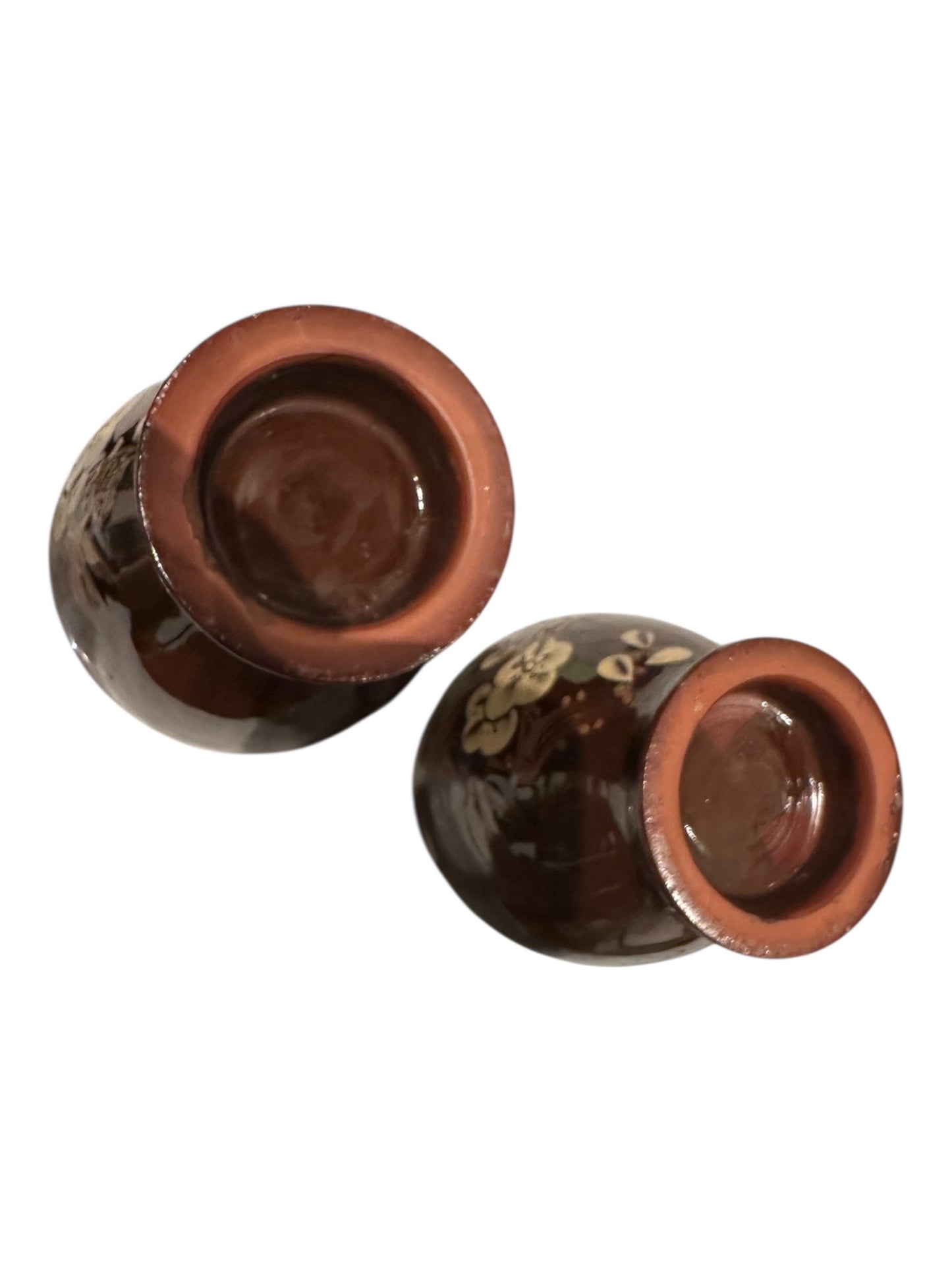 Pair of brown-glazed floral vases tipped on sides exposing unglazed terracotta bases