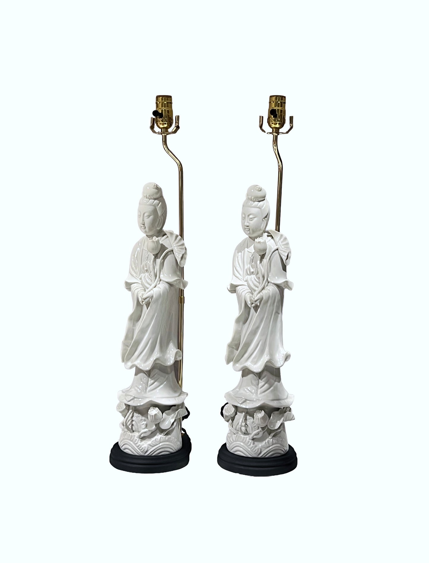 Pair of white figural table lamps, three-quarter view on black wood bases