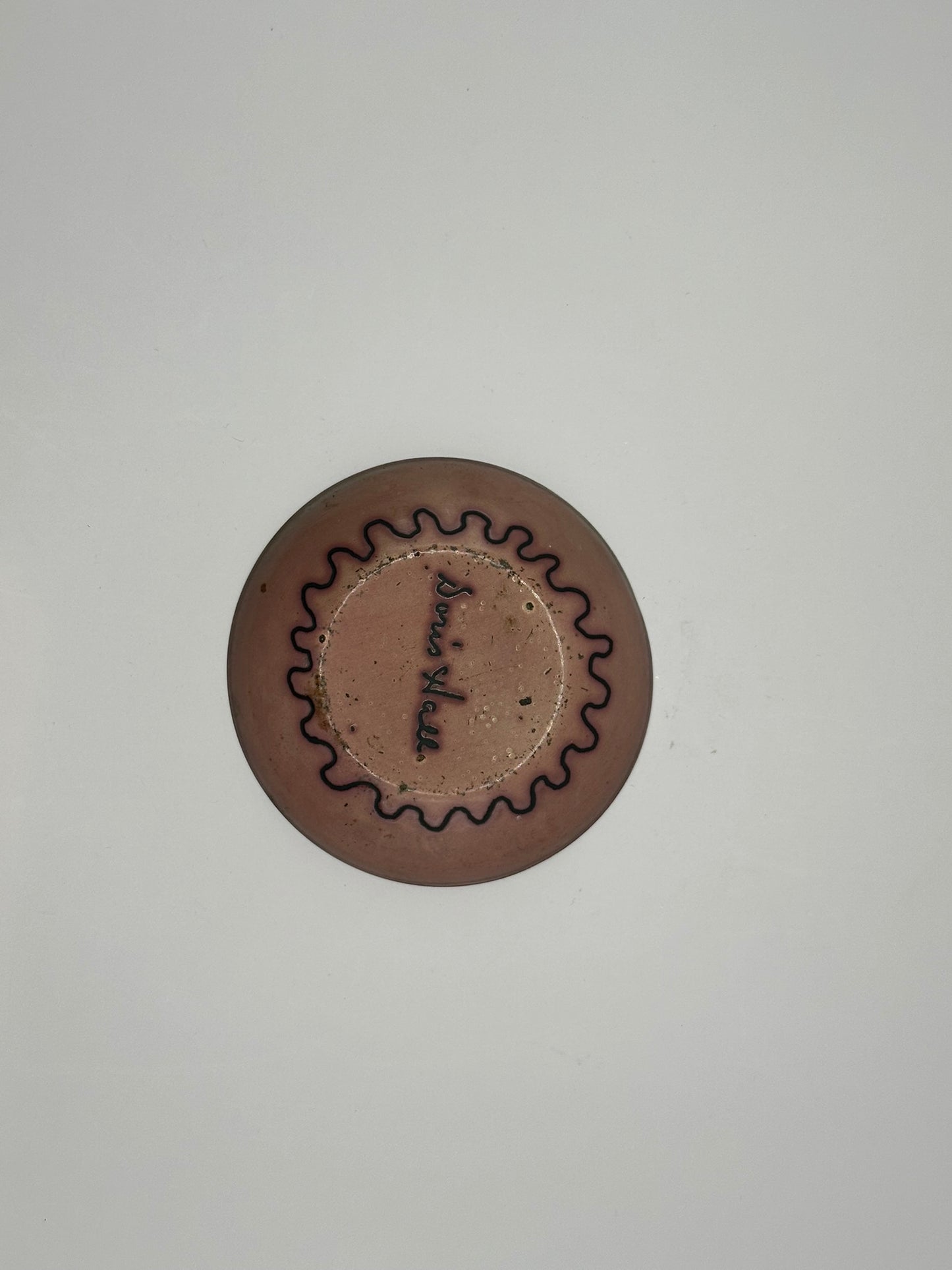 Underside of Doris Hall small dish, rose-copper glaze with black scalloped wave ring, signed 'Doris Hall'