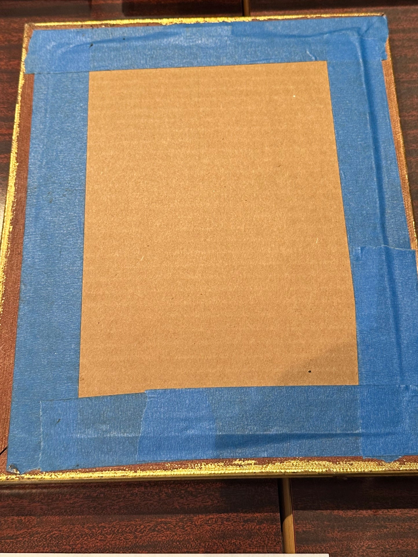 Back of "Infant Jesus" frame, brown cardboard backing secured with blue painters tape