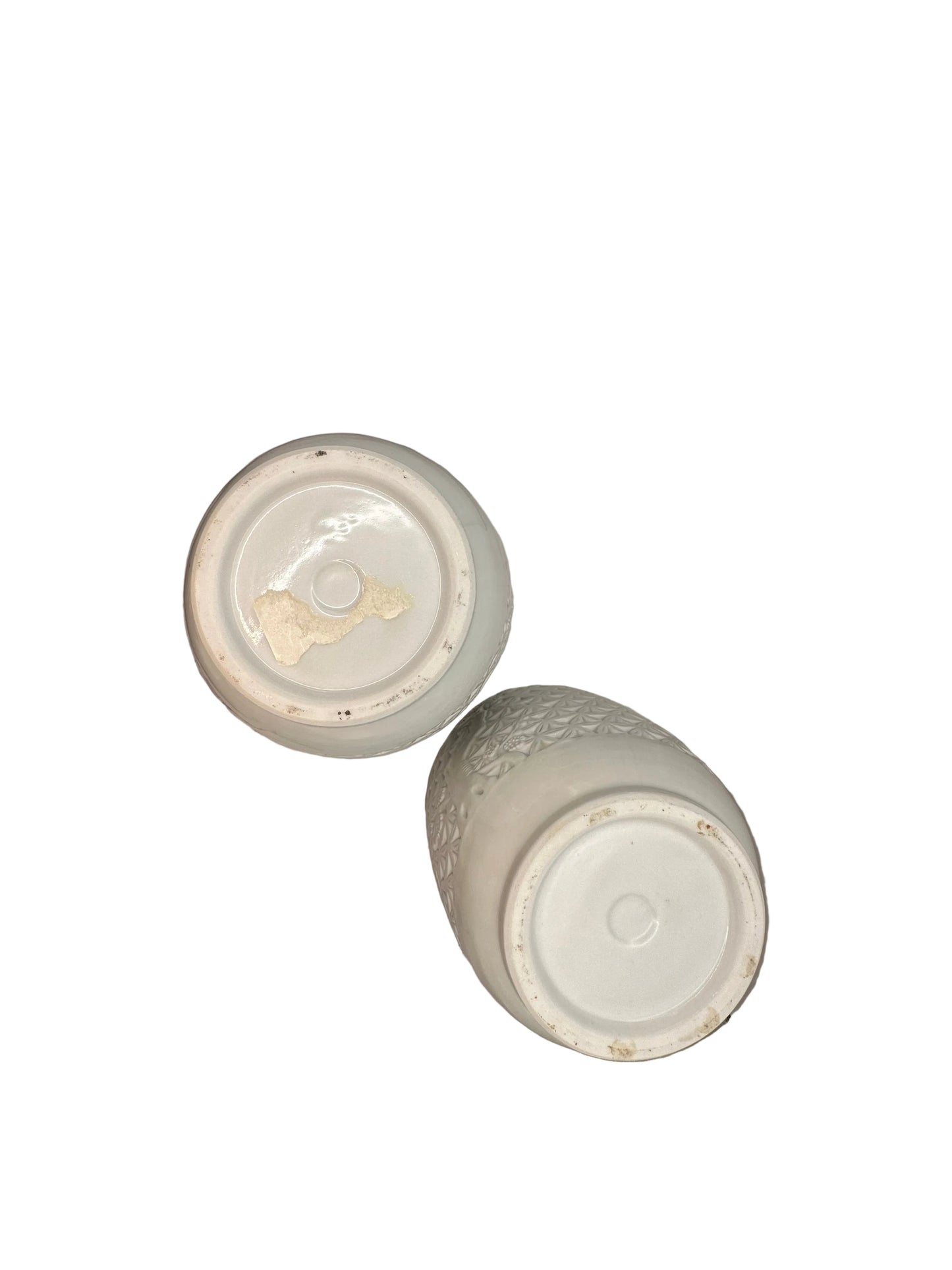 Undersides of the two white porcelain vases showing the glazed foot rims