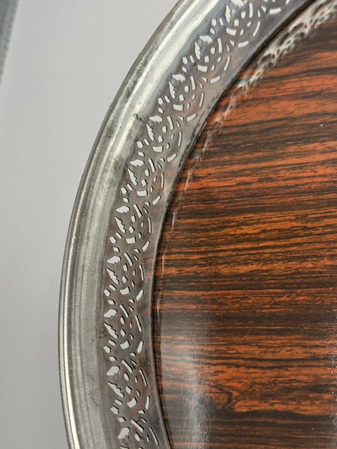 Detail of the pierced gallery rim against the rosewood tray surface