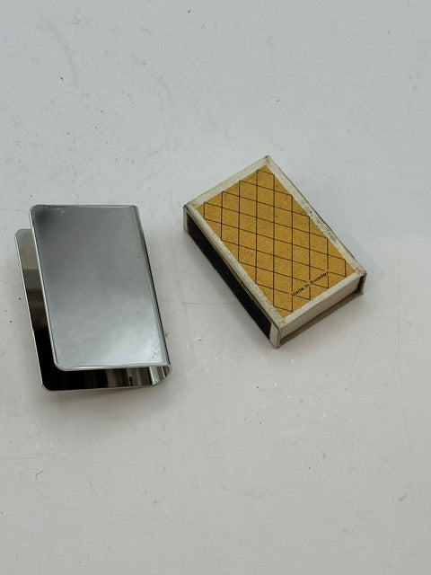 Silver-plate matchbox cover and matchbox lying side by side