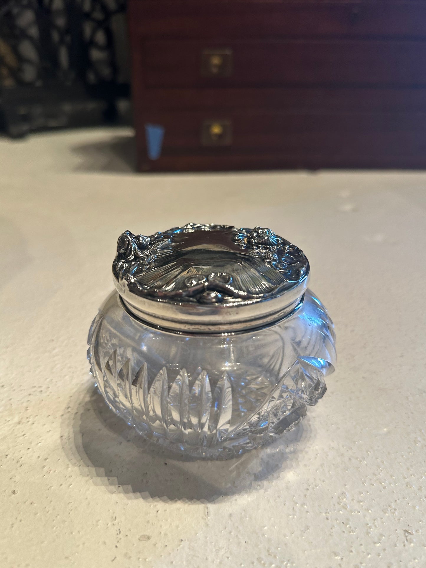Antique cut-crystal dresser jar with sterling silver Art Nouveau lid on vanity, front view