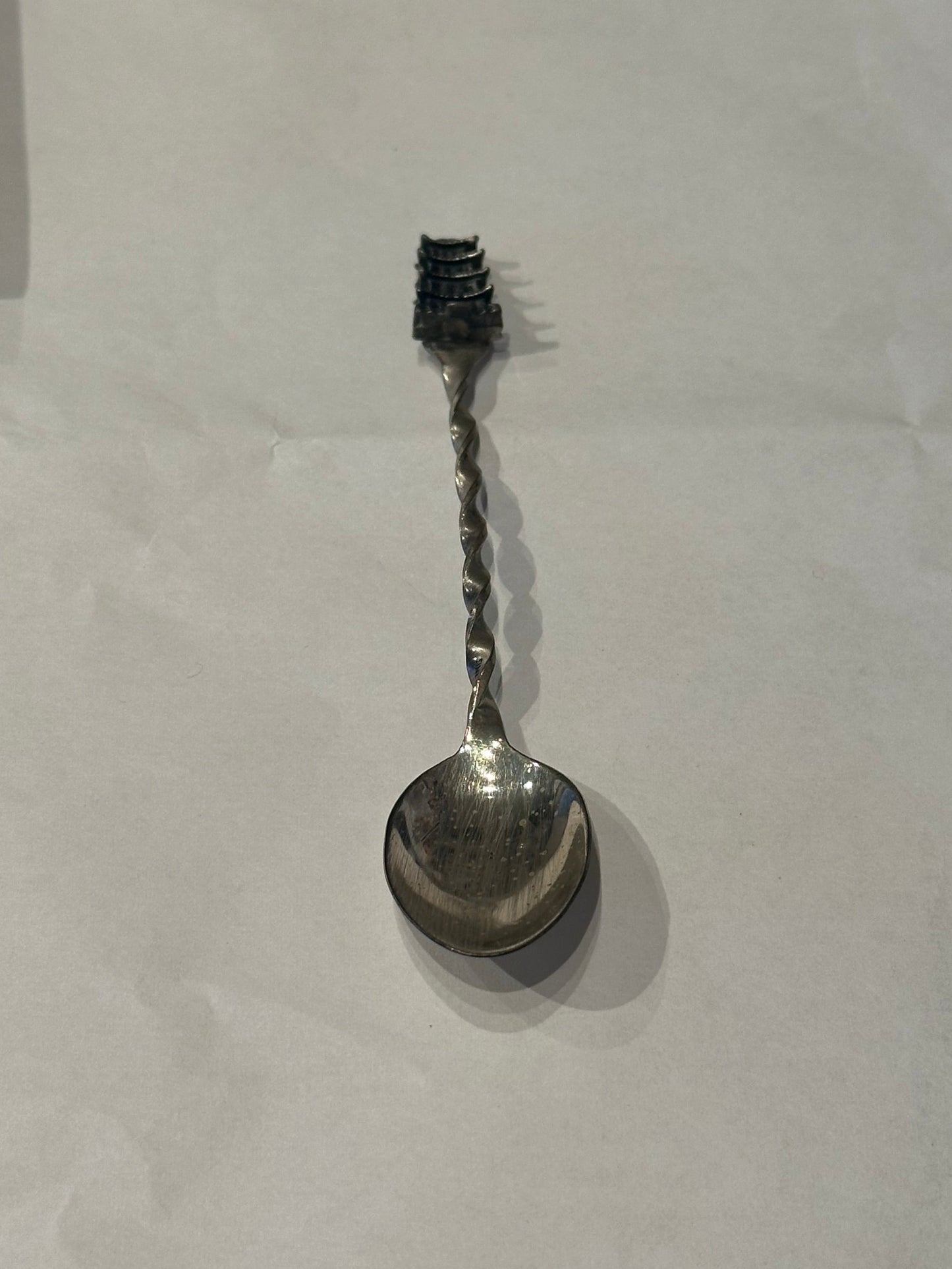 Sterling silver pagoda demitasse spoon, diagonal full view with pagoda finial above the twisted handle.