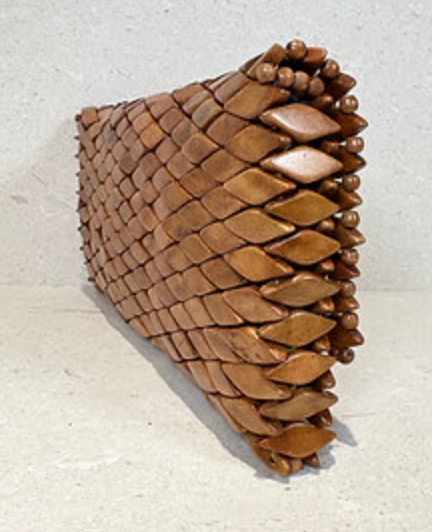 Side angled view of Ma'aM Kind woven wood clutch showing depth and beaded trim