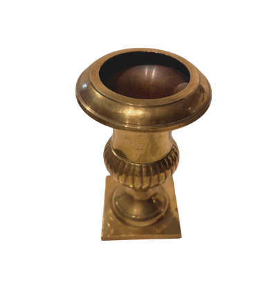 Angled overhead view of a polished brass Neoclassical urn showing its wide circular opening, flared rim, darkened interior, vertically fluted lower body, and square pedestal base.