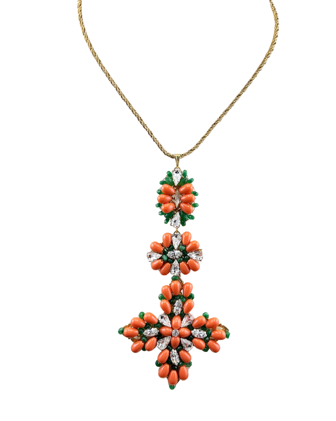 Triple coral cross necklace close-up, coral beads and crystal flowers with green accents on gold chain