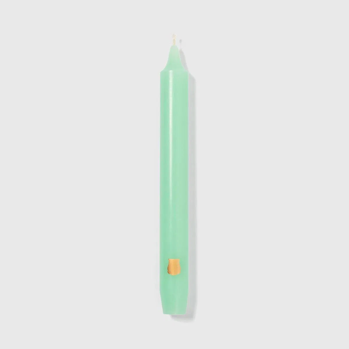 Pale green Vert d'Eau Trudon Madeleine taper candle upright with a gold crest