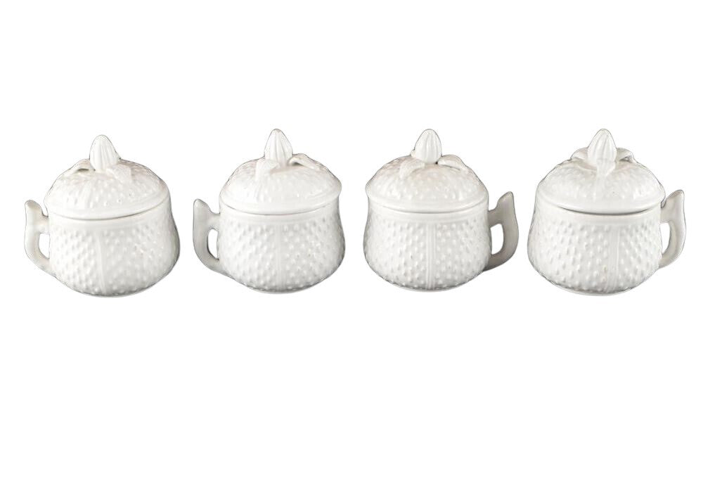 Set of four Mottahedeh white strawberry ceramic pots de creme with lids, lined up