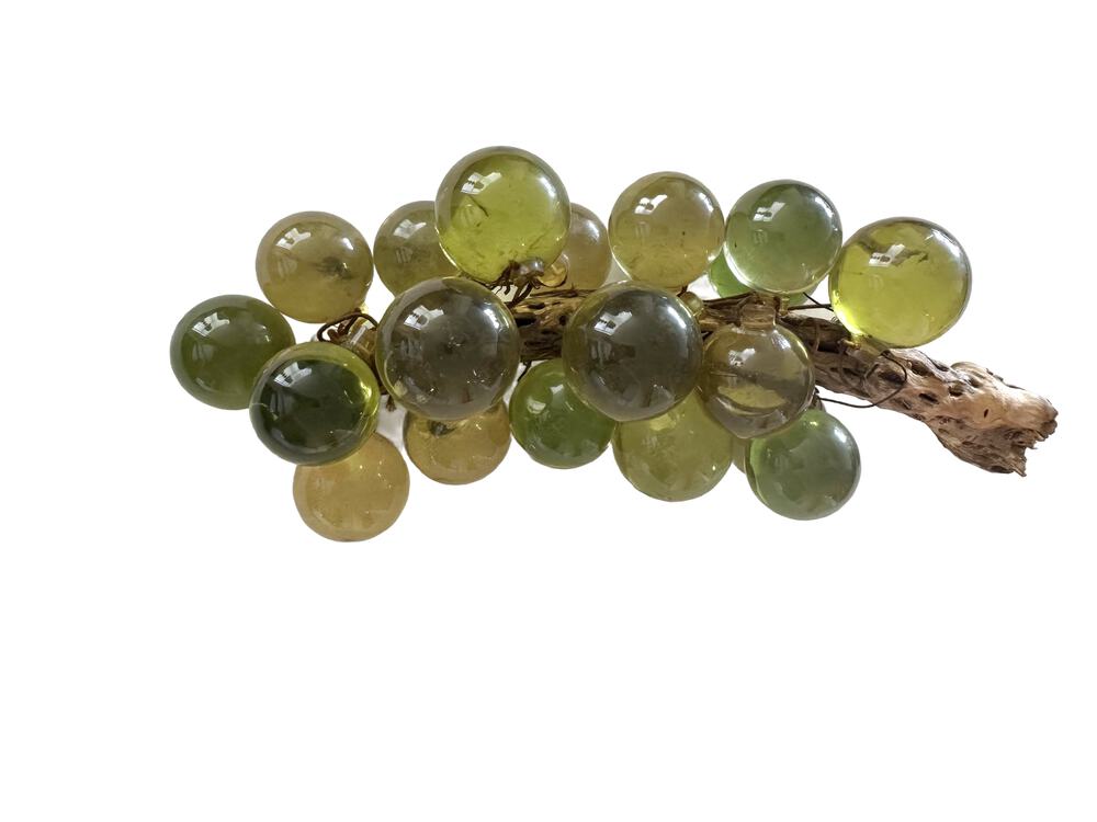 Vintage acrylic grape cluster, mix of green, amber and smoky-grey translucent spheres with gnarled wood stem at right.