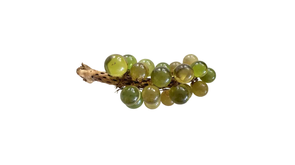 Vintage acrylic green grapes cluster on a natural wood stem, side view with translucent green and amber spheres on white.