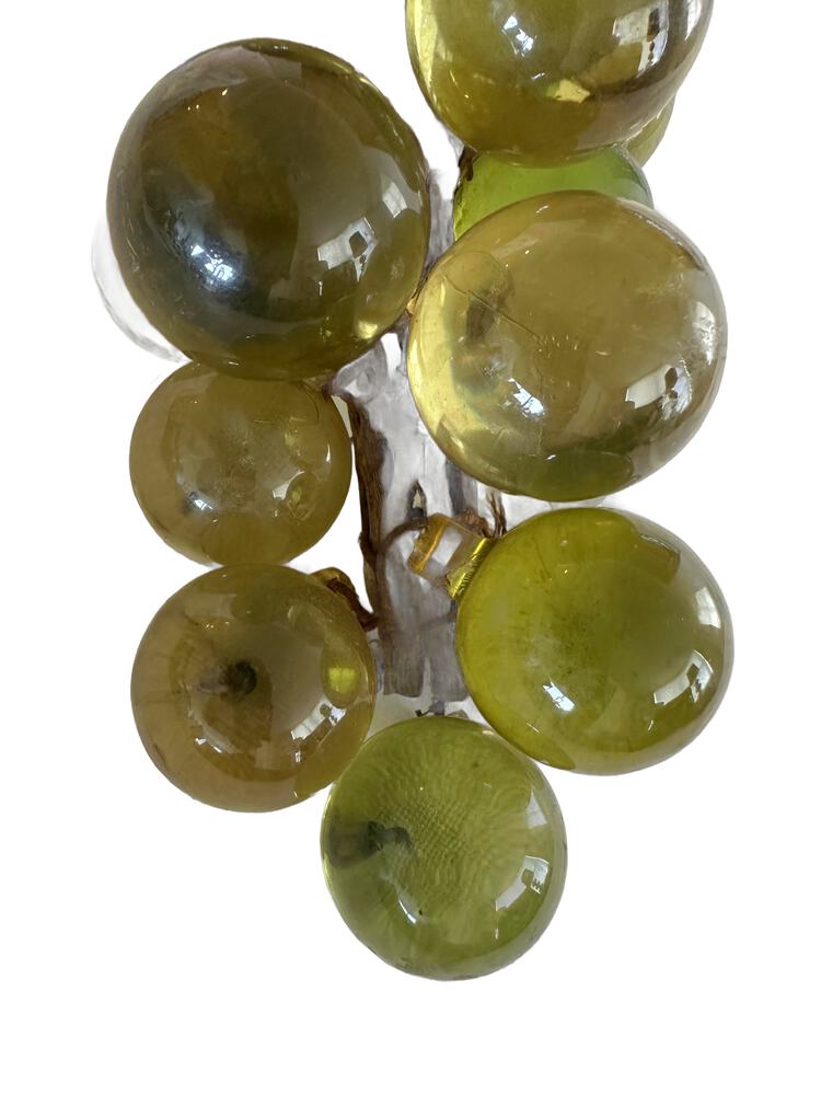 Close-up of the vintage acrylic grapes showing the smooth translucent green and amber spheres.