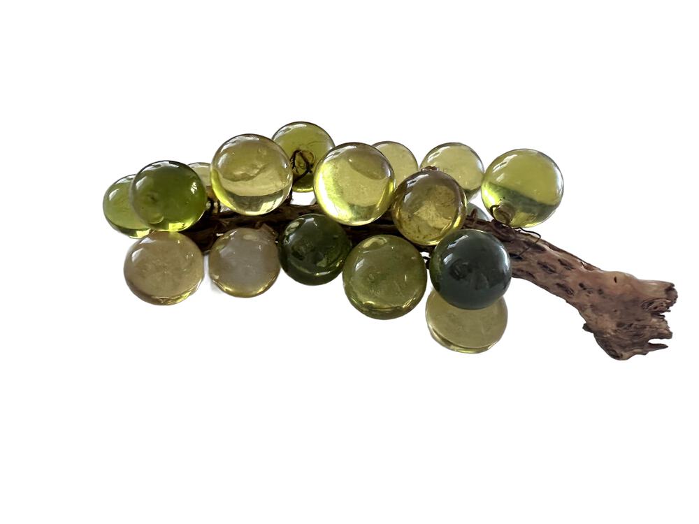 Vintage acrylic green grapes on a wooden stem, side profile showing glossy green and yellow translucent spheres.
