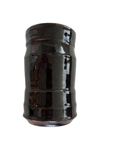 Studio pottery vase, front view of the ribbed cylinder with glossy near-black glaze.
