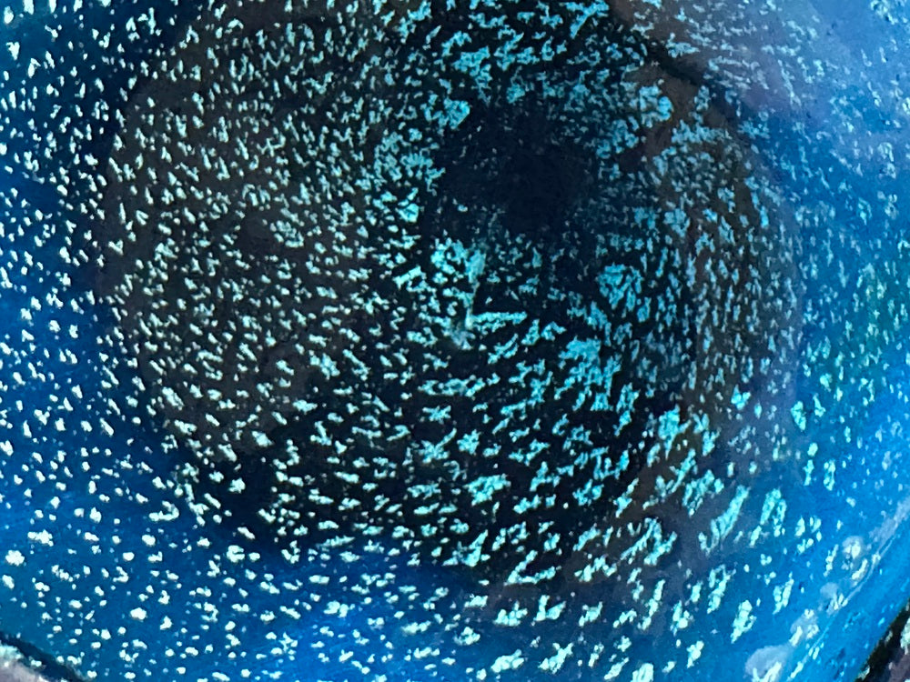 Macro close-up of the blue glass showing dense controlled bullicante bubbles.