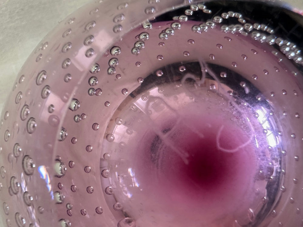 Close-up of the amethyst glass showing rows of controlled bubbles and a deep purple base.