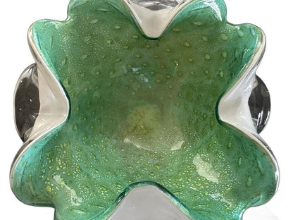 Top-down view into green Murano glass dish showing gold-fleck bubbled interior