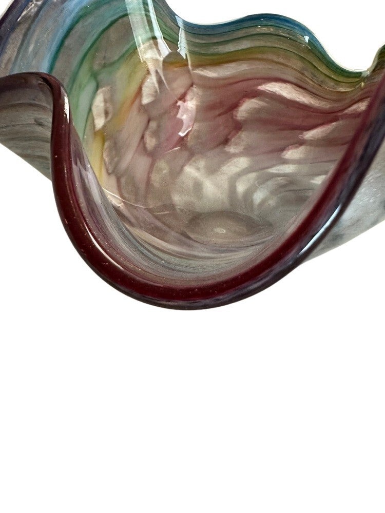 Close-up of the ruffled rim of the Murano style glass bowl, deep red edge over rainbow swirl