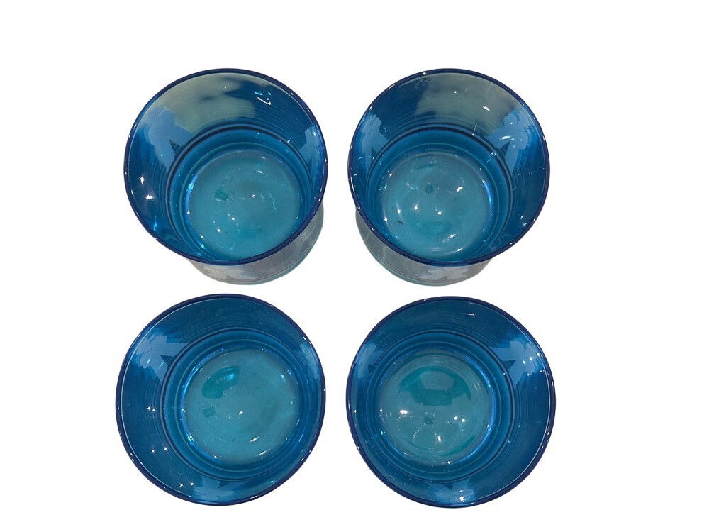 Top-down view of four blue sailor glasses showing their tinted interiors and rounded bases.