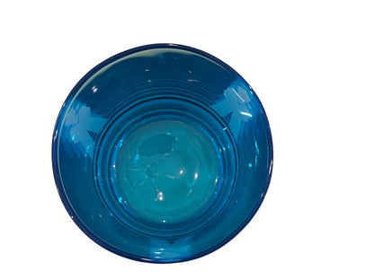 Top-down view into a blue rocks glass showing the base and sailor silhouettes through the glass.