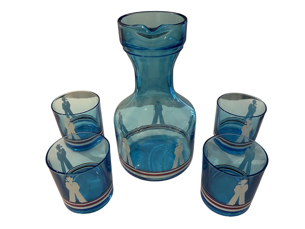 Blue sailor-motif carafe set with four striped tumblers arranged around it.