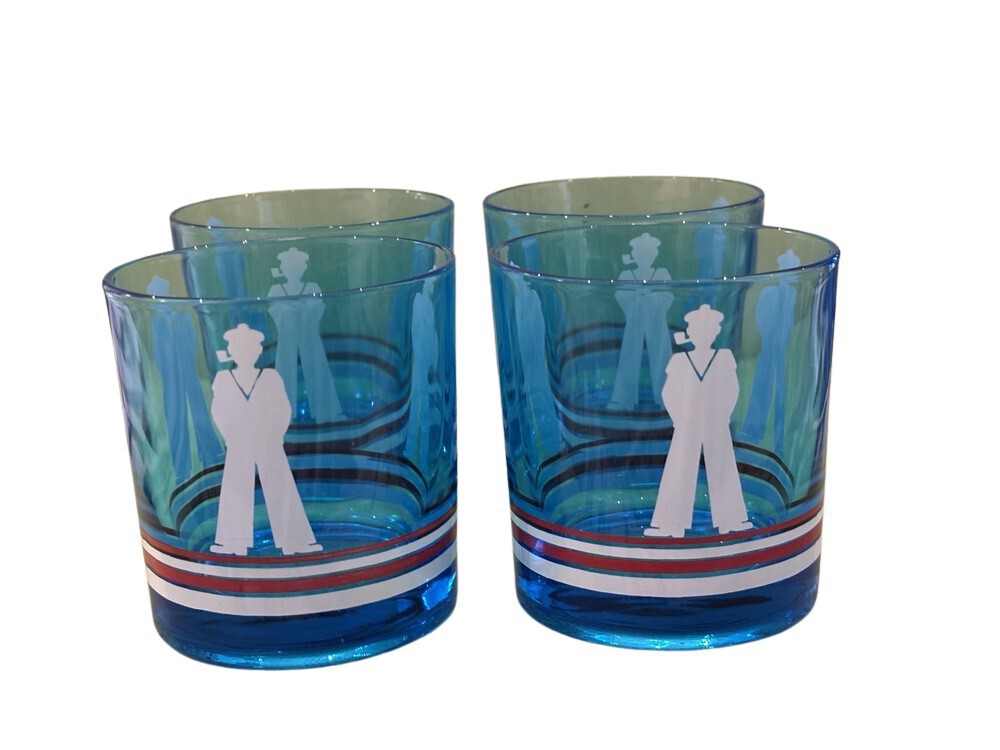 Four blue sailor-motif rocks glasses grouped together, white sailor figures above red, white and blue stripes.