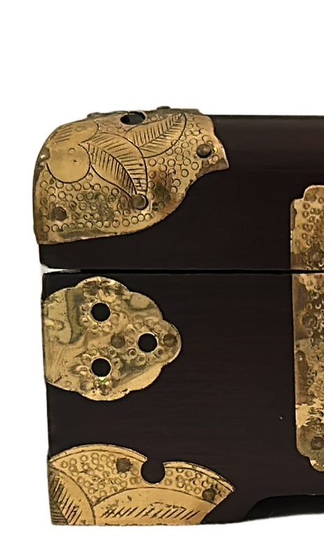 Close-up of the box's engraved brass corner mounts with floral and leaf detailing