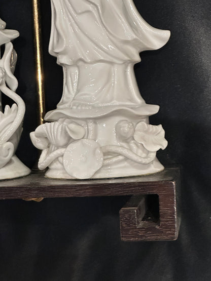 Blanc de Chine figure rising from a lotus base on the lamp's dark wood Greek-key stand