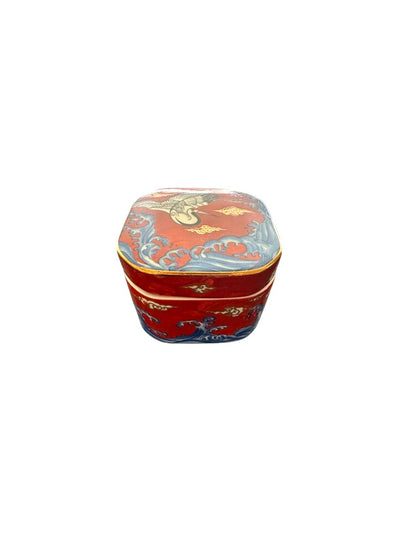 Vintage porcelain small box, assembled, showing red crane lid and blue wave base, three-quarter view.