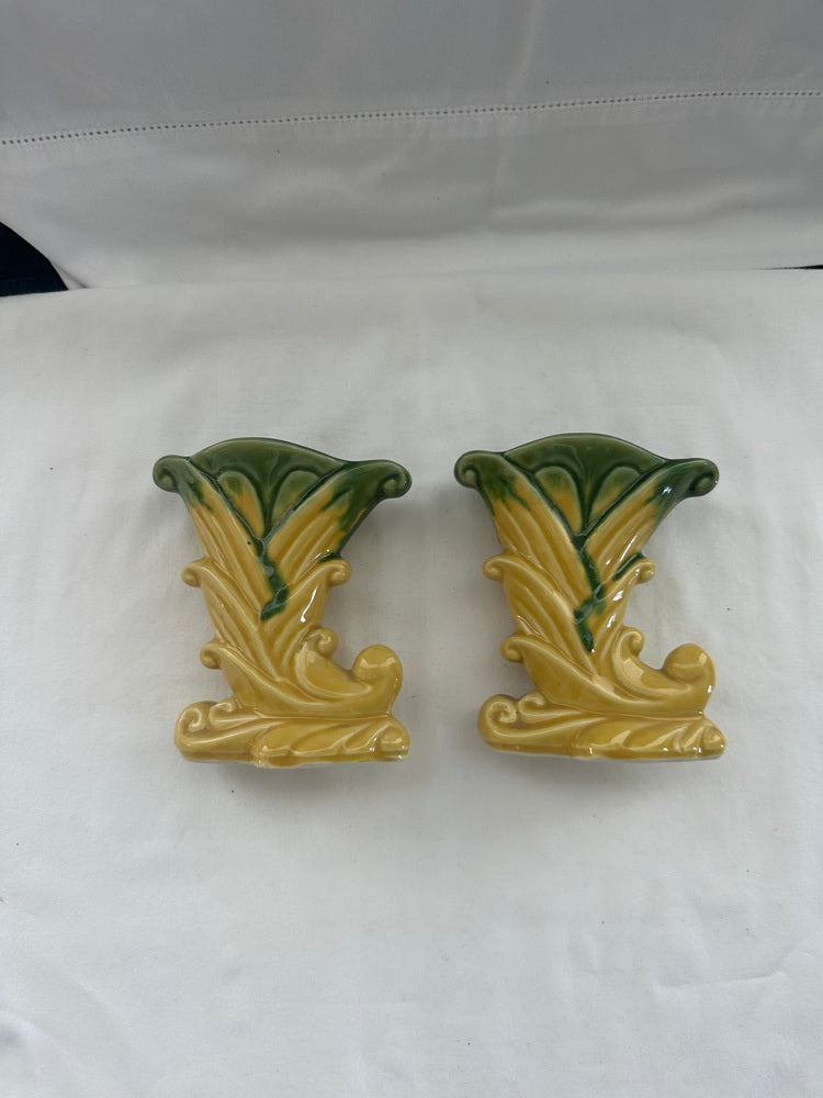 Pair of vintage Shawnee Pottery cornucopia vases on white cloth, yellow-green leaf-scroll form, front view