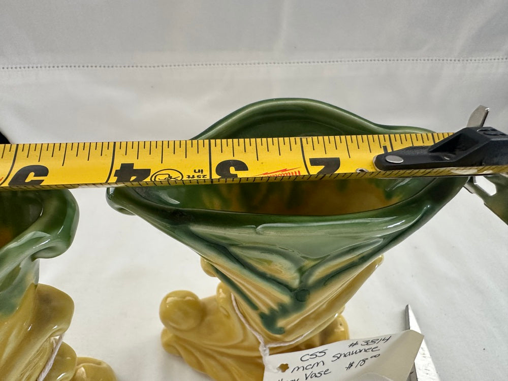 Tape measure laid across the flared opening of a vintage Shawnee Pottery vase to measure its width