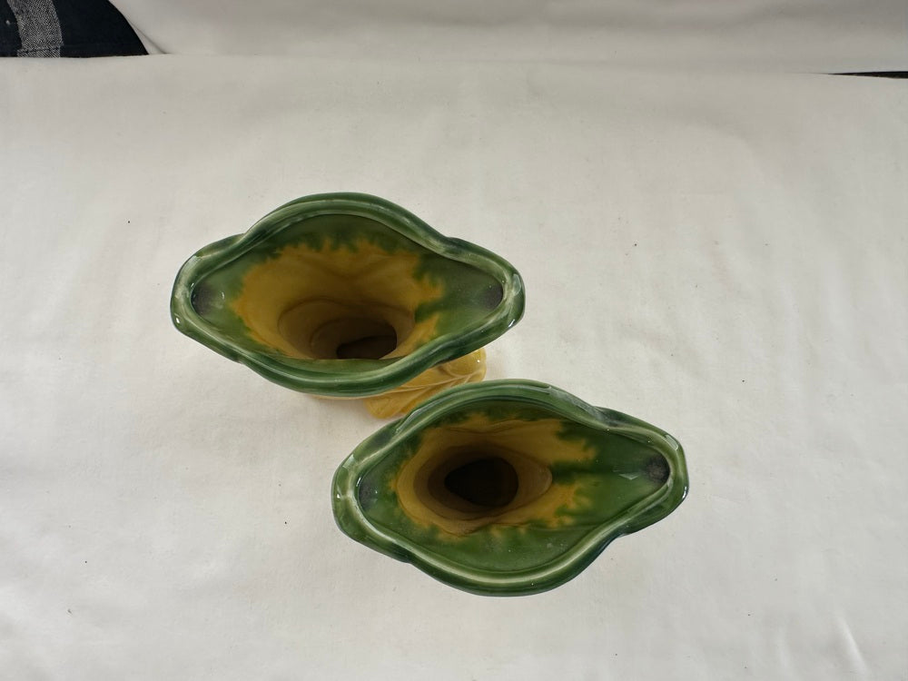 Two vintage Shawnee Pottery vases from above, green-rimmed flared openings with yellow interiors