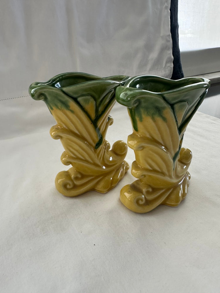 Pair of vintage Shawnee Pottery cornucopia vases displayed upright on white cloth by a window
