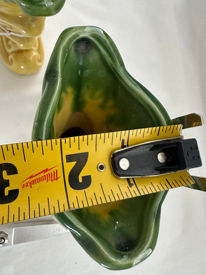 Close-up into the green-rimmed opening of a vintage Shawnee Pottery vase with a tape measure