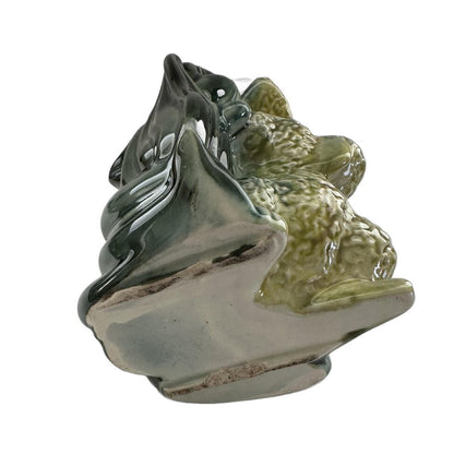 Vintage Hull poodle vase, three-quarter rear view of yellow-green poodle and dark green leaf-form vessel