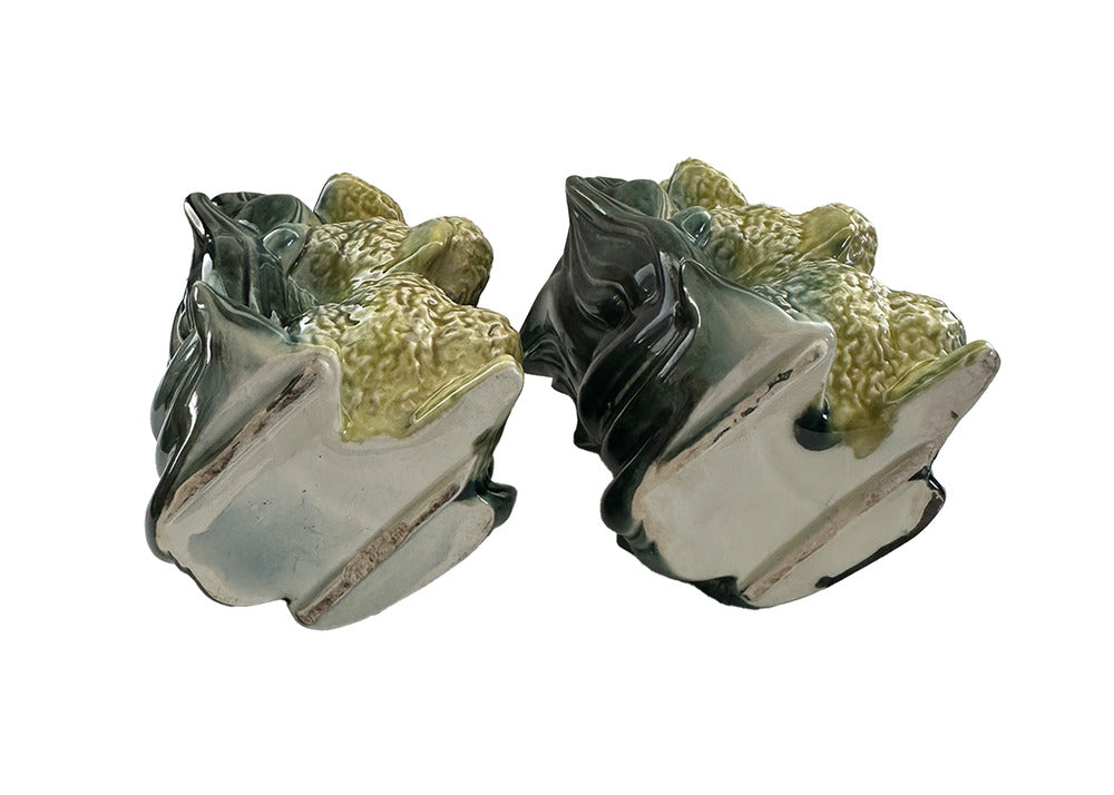 Pair of vintage Hull poodle vases tilted to reveal unglazed bases and green leaf-form vessel backs