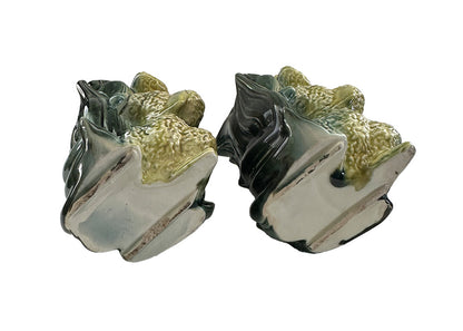Pair of vintage Hull poodle vases tilted to reveal unglazed bases and green leaf-form vessel backs