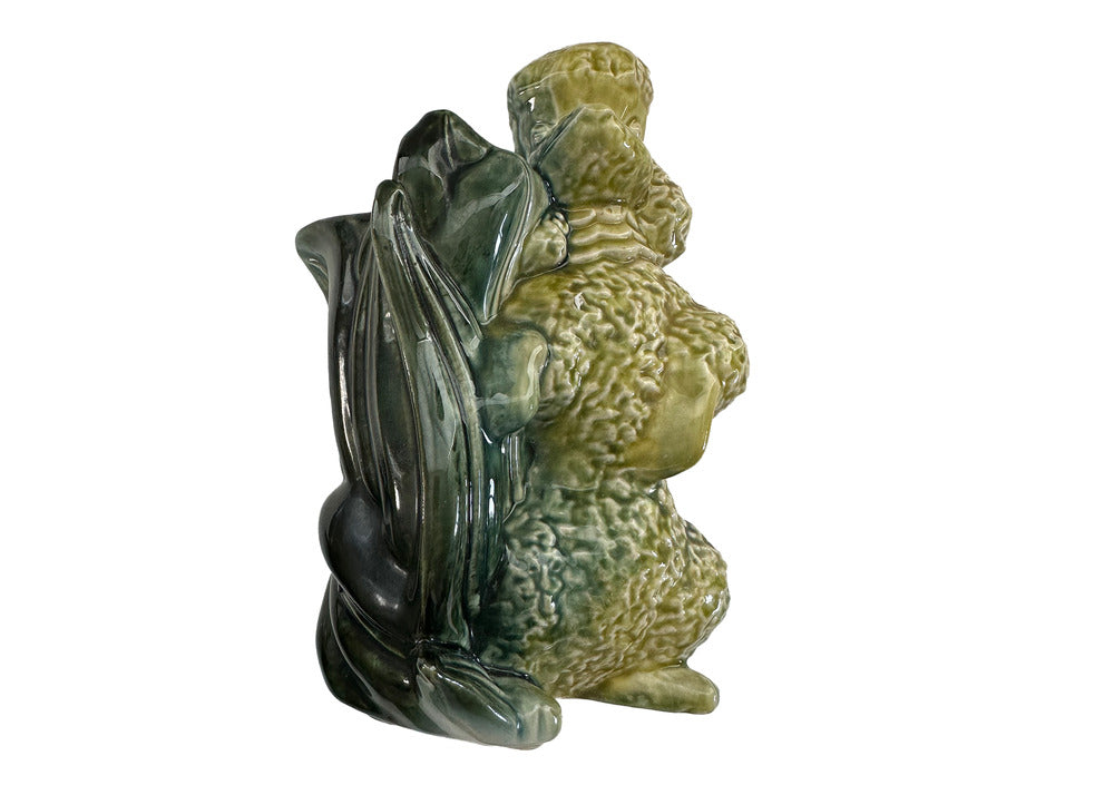 Vintage Hull poodle vase, rear view showing dark green leaf-form vessel behind a yellow-green seated poodle