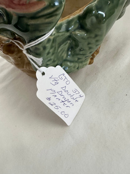 Close-up of the planter's handwritten paper hang tag beside the green glazed dragon body