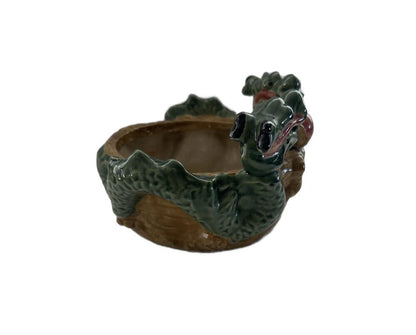 Ceramic double dragon planter, side view with a green dragon head and scaled body over the brown bowl