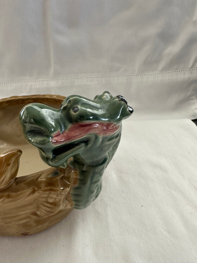 Close-up of one green glazed dragon head on the ceramic double dragon planter, with pink mouth detail