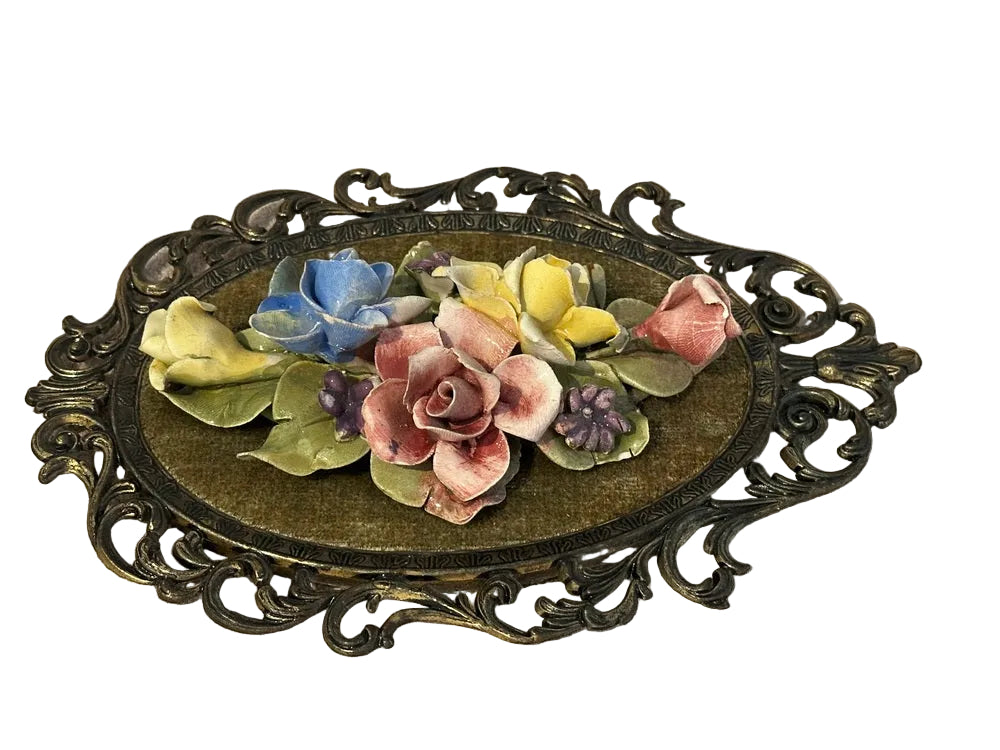 Close angled view of raised porcelain roses on Capodimonte plaque, pink rose among blue and yellow blooms