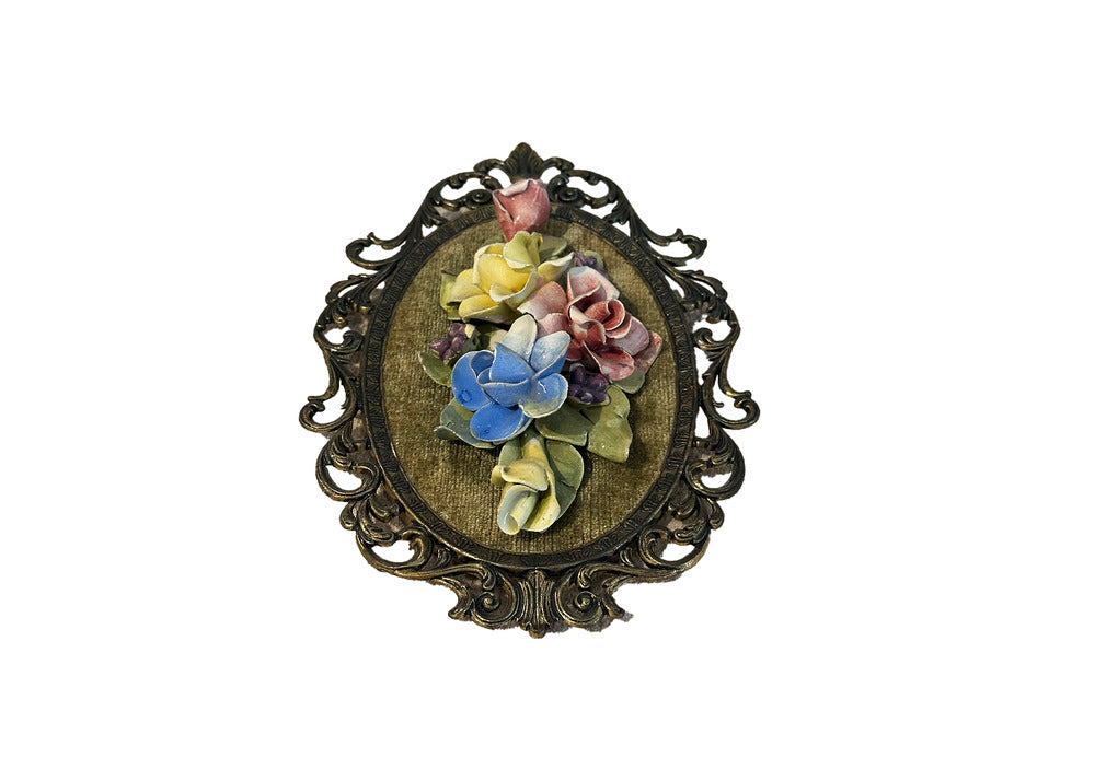Capodimonte floral wall plaque viewed slightly angled, porcelain roses on green velvet in gilt-metal frame