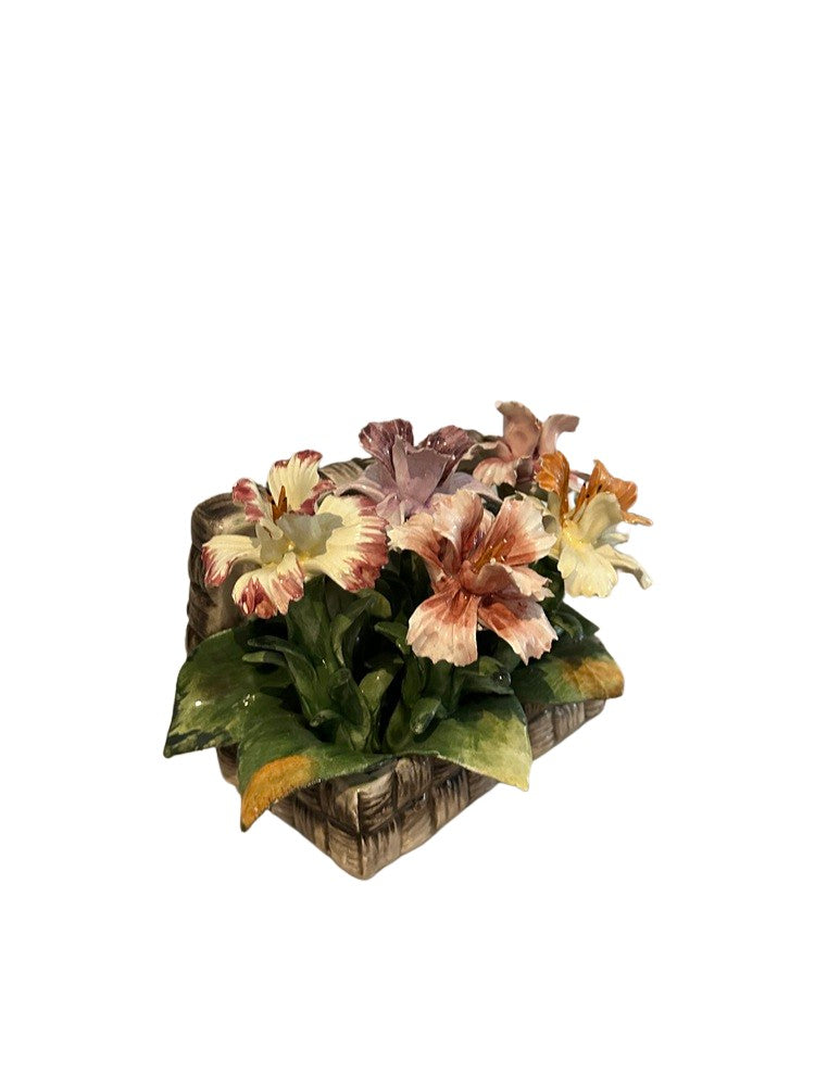 Three-quarter top view of Capodimonte porcelain flowers in a woven-basket base