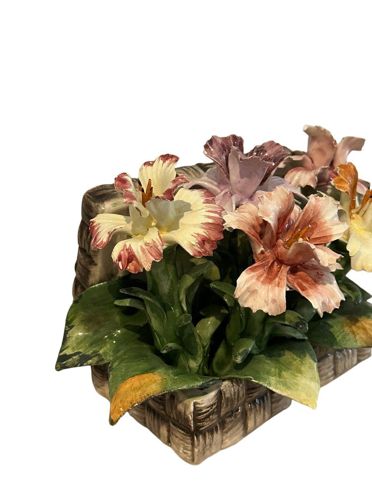 Close-up of peach, pink and lavender Capodimonte porcelain lilies in a woven ceramic basket