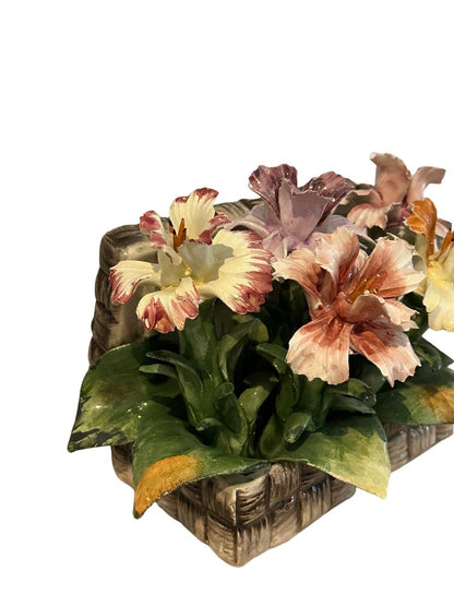 Close-up of peach, pink and lavender Capodimonte porcelain lilies in a woven ceramic basket