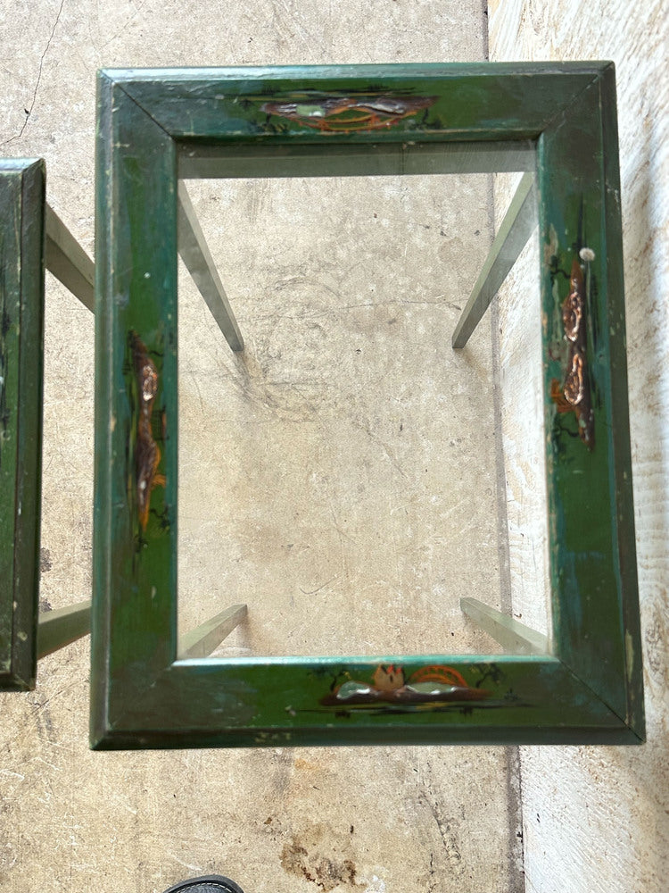 Top view of green lacquered nesting table frame, hand-painted scenes at corners, missing glass
